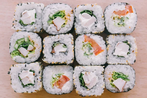 Sushi rolls on wooden table, Japanese food, top view.