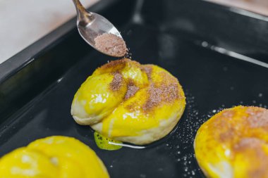 Kadın yağmurlama tatlı tarçın ile kayrak plaka üzerinde rulo.