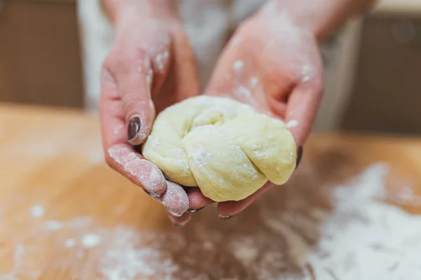 Руки выпекают тесто на деревянном столе — стоковое фото