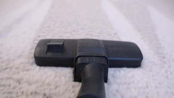 POV of vacuum cleaner brush in focus moving around the floor close up