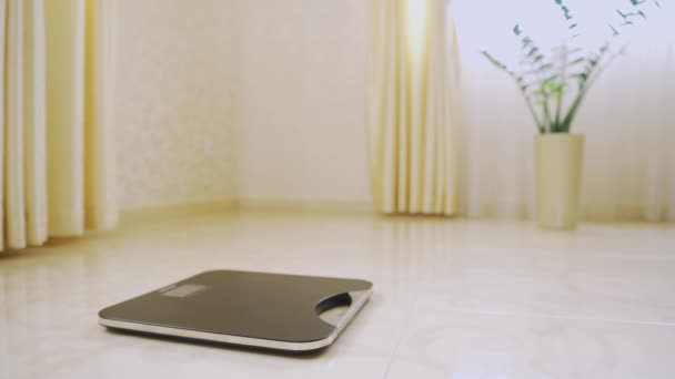 A man in his pajamas morning measures his weight on a scale of health closeup — Stock video