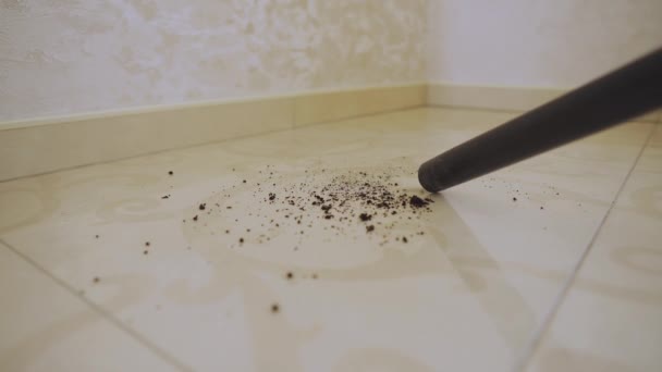 Woman using a vacuum cleaner to clean tiles in a home interior — Αρχείο Βίντεο