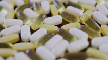 Masadaki sarı ve beyaz haplar, yavaşça makroya odaklanıyor.