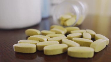 Masadaki sarı haplar, yavaşça şişeye yaklaşıyorlar, makro çekime odaklan.