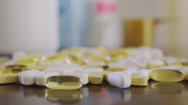 Comprimidos e vitaminas close-up sobre a mesa boneca tiro usando profundidade rasa de campo — Vídeo de Stock