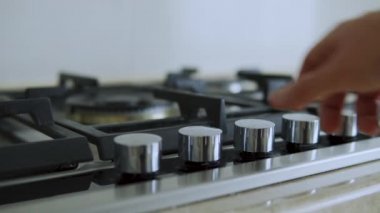 Mutfak ocağını açan kişi mavi alevle gaz ocağını yakar 
