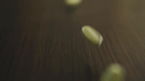 Pílulas amarelas e vitaminas closeup cair sobre a mesa usando profundidade rasa de campo — Vídeo de Stock