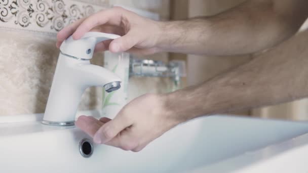 早上醒来后 一个人在水龙头下洗手 这时他正靠得很近 — 图库视频影像
