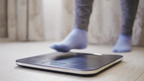 Γυναίκα πόδια βήμα σε κλίμακες ζύγισης. Θηλυκός έλεγχος σωματικού βάρους στο δωμάτιο. — Αρχείο Βίντεο