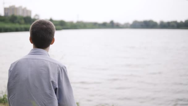 젊은이는 낮에 공원 근처의 신선 한 공기 속에 앉아 명상을 한다 — 비디오