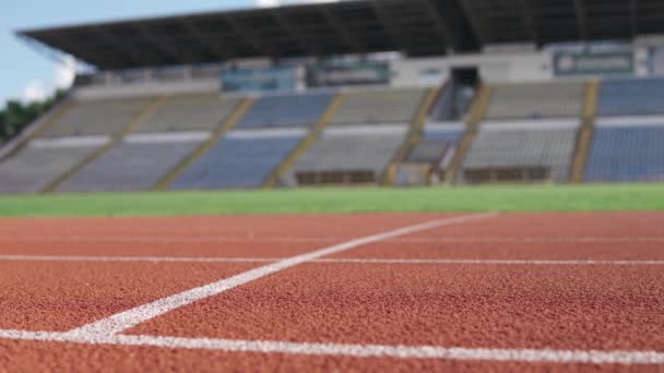Спортсмен бегает по стадиону летом крупным планом — стоковое видео