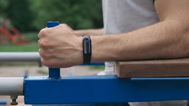 Primer plano de atleta fuerte haciendo entrenamiento de prensa al aire libre en el patio de recreo — Vídeos de Stock