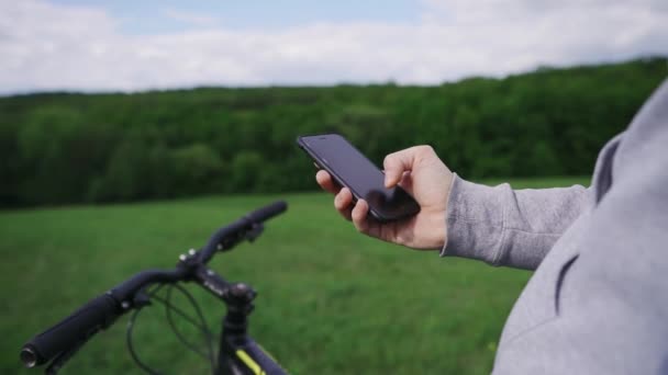 Courier ποδήλατο παίρνει μια παραγγελία για την παράδοση τροφίμων σε ένα smartphone — Αρχείο Βίντεο