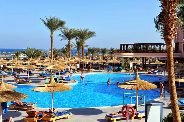 HURGHADA, EGIPTO - 14 DE OCTUBRE DE 2013: Personas no identificadas nadan y toman el sol en la piscina de un complejo tropical de lujo en Egipto. Hurghada, Egipto . — Foto de Stock