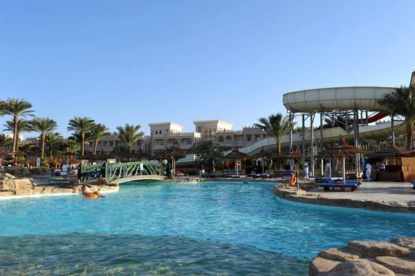 HURGHADA, EGIPTO - 14 DE OCTUBRE DE 2013: Personas no identificadas nadan y toman el sol en la piscina de un complejo tropical de lujo en Egipto. Hurghada, Egipto . — Foto de Stock