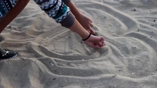 Девушка рисует сердце в песке на берегу Азовского моря — стоковое видео