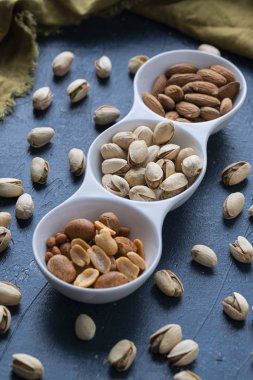 Beyaz seramik kasede kavrulmuş fındık ve tuzlu fıstık.