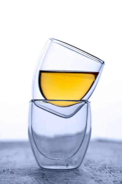 double glass espresso cups on black background with tea