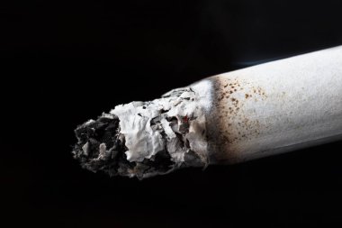 Siyah bir arka plan üzerinde yanan bir sigara makro çekim
