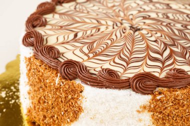 Beyaz ve sütlü çikolata buzlanma, Hindistan cevizi pul ve bisküvi yanında lezzetli pasta