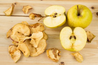 Kurutulmuş ve taze elma ahşap arka plan üzerinde