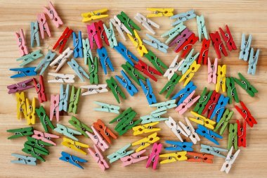 Ahşap arka plan üzerinde renkli clothespins dönüştürün