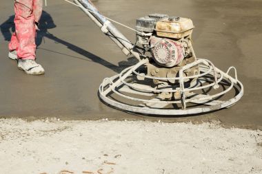 Working power trowel machine on a fresh concrete surface clipart