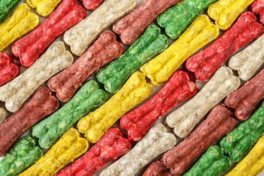 Colored bone shaped dog treats background clipart