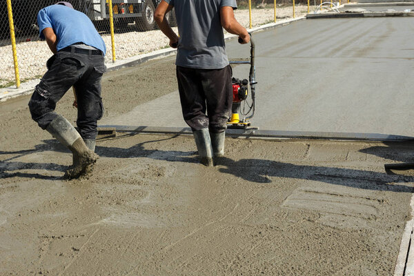 Smoothing concrete with vibrating screed machine