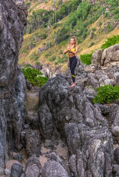 Femme faisant du yoga sur un rocher . — Photo