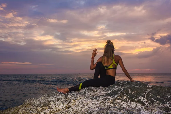 Gün batımı germe kadın. Genç kadın yoga yaparken 