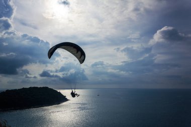 Okyanusta parasailing adam. Bir paraşüt üzerinde uçan bir kişi 