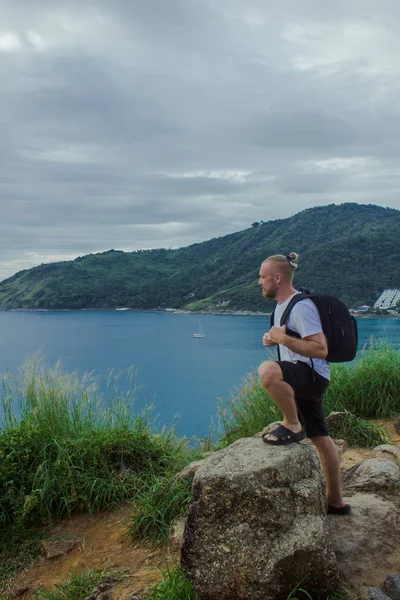 Homem com mochila a olhar para o oceano. Vista lateral de um turista — Fotografia de Stock