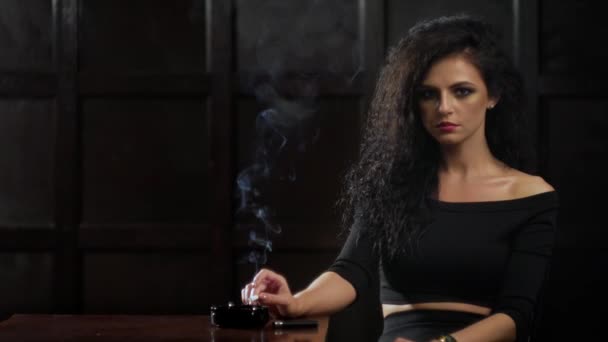 Mladá bruneta žena kouří cigaretu. — Stock video