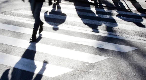Cruce borroso de cebra con peatones haciendo largas sombras —  Fotos de Stock
