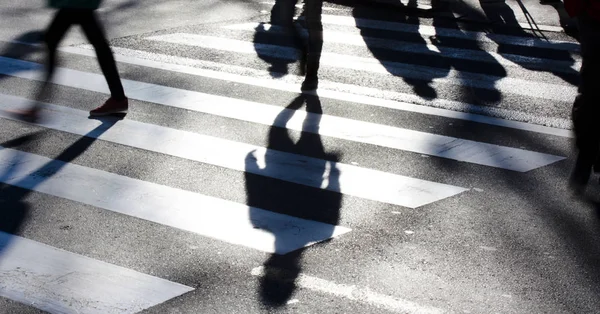 Cruce borroso de cebra con peatones haciendo largas sombras —  Fotos de Stock