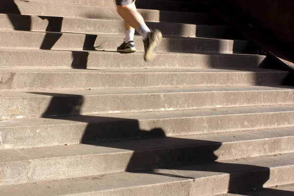 Jogging up the stairs with long shadows — Stock Photo, Image