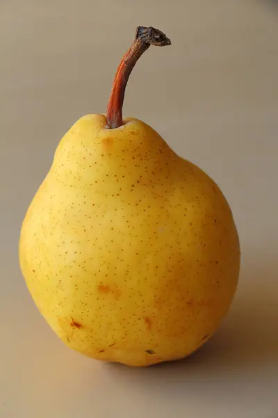 Keltainen päärynä pöydällä — kuvapankkivalokuva