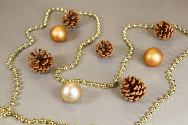 Christmas balls, pine cones and pearls tinsel — Stock Photo, Image