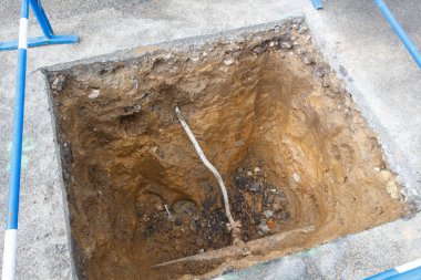 Boruların tamiri için bir caddede delik