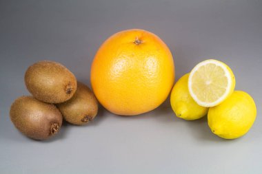 Ahşap arka planda greyfurt, kivi ve limon.