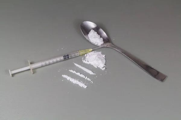 Linie kokainowe gotowe do wąchania na stole i strzykawce — Zdjęcie stockowe