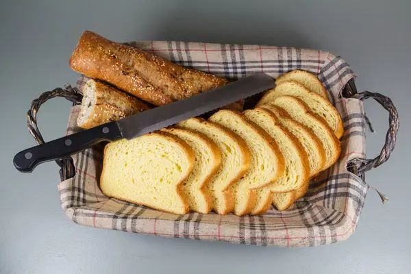 Baguette chleb, brioche i nóż w koszu na chleb — Zdjęcie stockowe