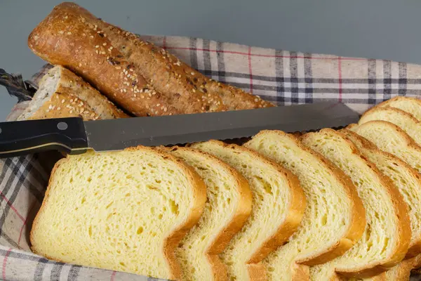 Baguette chleb, brioche i nóż w koszu na chleb — Zdjęcie stockowe