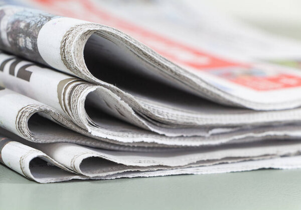 Куча сложенных французских газет на столе
