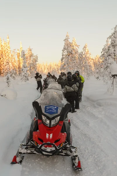 Motos de nieve con los pueblos en invierno —  Fotos de Stock