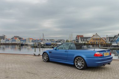  BMW M car at a small harbor clipart