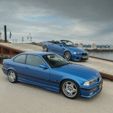  BMW M cars at a small harbor clipart
