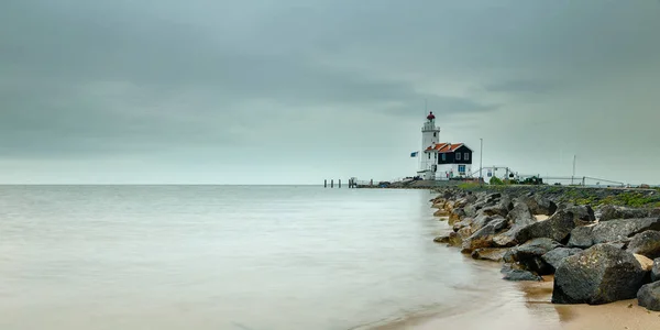 Mar brumoso y faro en la costa rocosa — Foto de Stock