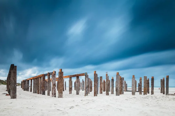 Pylônes abandonnés sur sable — Photo